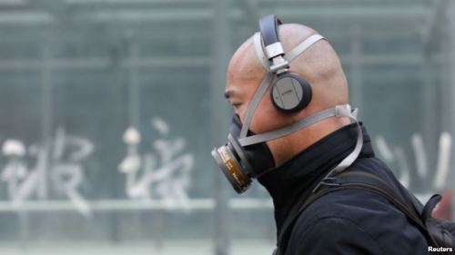 Seorang pria China harus mengenakan masker akibat udara kotor dan kabut asap yang menyelimuti Beijing. Polusi udara bisa terjadi karena asap kendaraan, asap dari cerobong pabrik, dan kabut asap dampak pembakaran hutan.