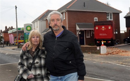 Pasangan Len dan Wilies di halaman depan rumahnya yang tertabrak truk jawatan pos Inggris.