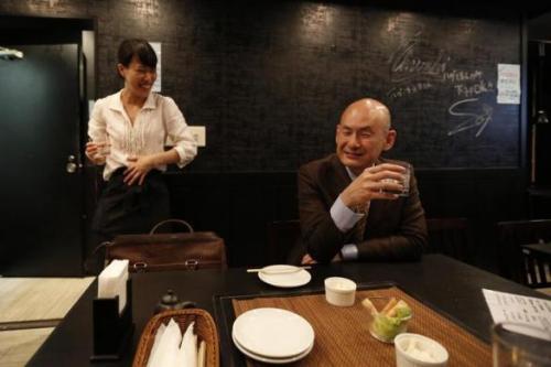 Shiro Fukai, 48, minuman suling semangat sebelah manajer Yoshiko Toyoda (L) di Otasuke "izakaya" gaya pub dan restoran di Tokyo 8 Mei 2014. REUTERS / Toru Hanai.