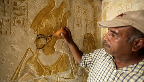Seorang pekerja sedang membersihkan debu yang menempel pada relief di enam makam kuno yang baru dibuka untuk umum di New Kingdom Cemetery, Saqqara, Mesir.