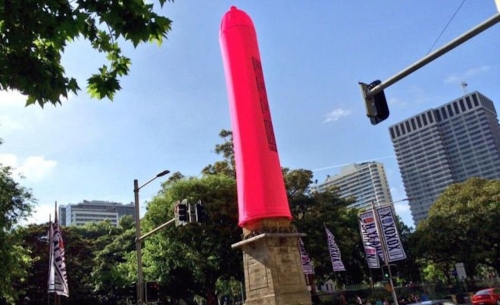 Akhirnya kondom raksasa merah jambu berdiri tegak membungkus obeliks.