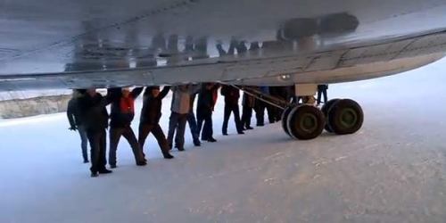 Sekalipun udara dingin melanda landas pacu, para penumpang dengan senang hati beramai-ramai mendorong pesawat ke landas pacu.