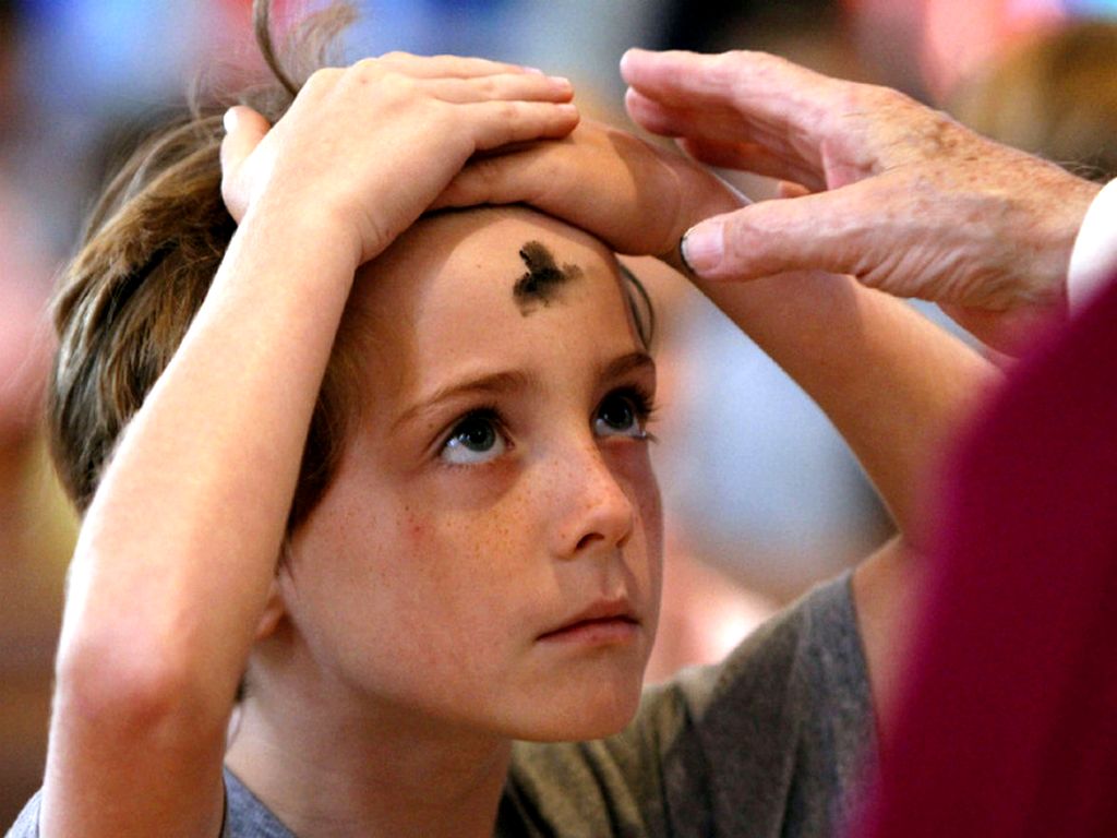 Tanda salib dari abu diberikan kepada anak pada dahinya saat umat merayakan Rabu Abu di Gereja Westminster, AS. Rabu Abu adalah hari pertama Masa Prapaska, ... - rabu-abu-pada-anak-kecil
