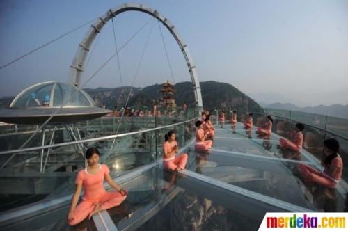 Sejumlah wanita berlatih yoga di atas panggung kaca yang berada di pinggir tebing di Beijing, China, Senin (20/6). Kegiatan ini dilakukan untuk menyambut perayaan Hari Yoga Internasional pada 21 Juni. 